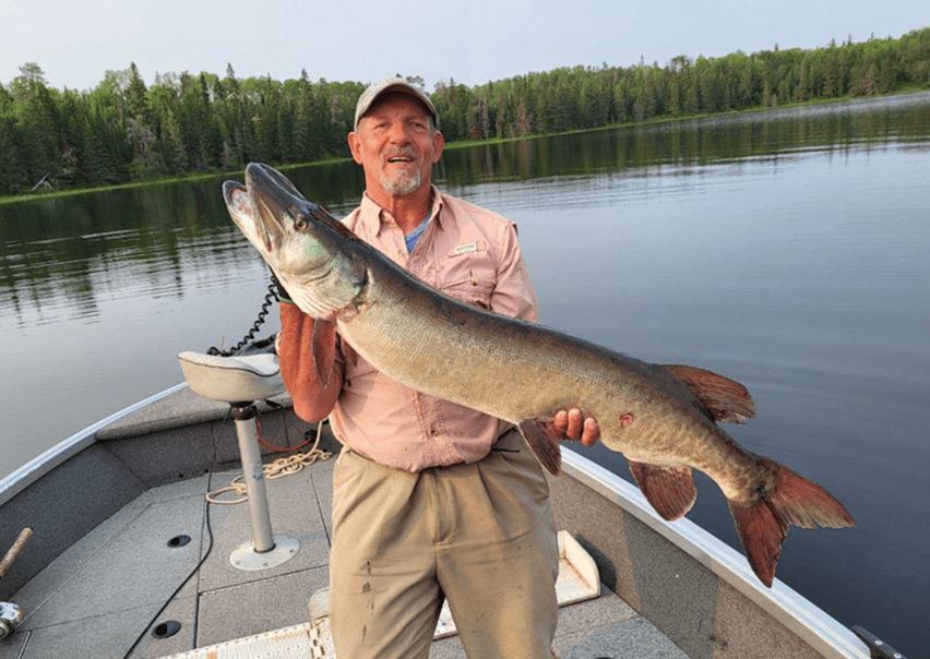 Old Man On The Boath Holding A Big Fish